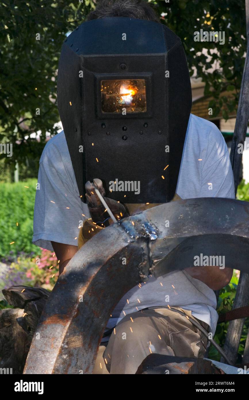 Soudage d'une pièce de métal au moyen d'une soudeuse électrique et d'une électrode de soudage. L'homme a soudé des métaux au moyen d'une soudeuse électrique et un Banque D'Images