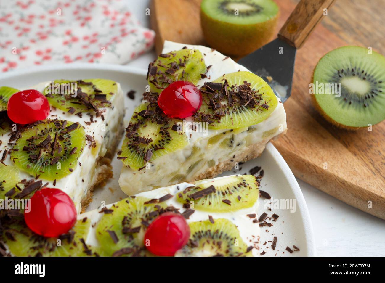 Yaourt et gâteau au kiwi avec une base de biscuits décorée de chocolat râpé. Banque D'Images
