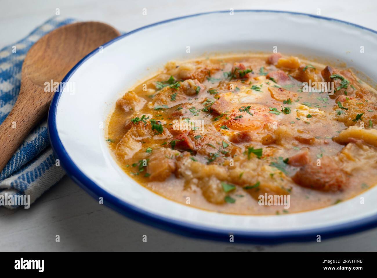 Soupe castillane avec des légumes et des morceaux de pain grillé avec un œuf au milieu. Banque D'Images