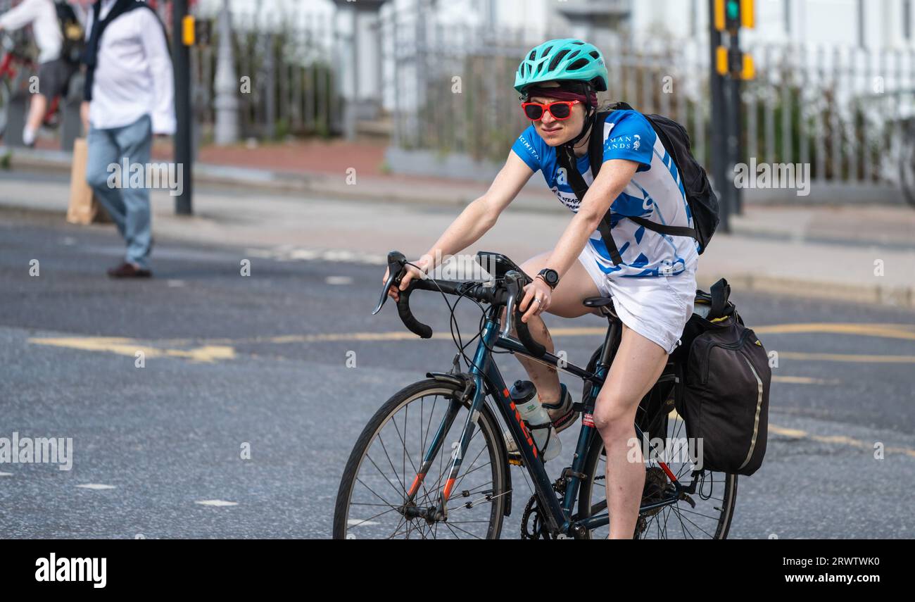 Jeune femme avec des lunettes de soleil à vélo ou vélo à pédales. Cycliste femme portant un casque de sécurité et un sac à dos avec valises au Royaume-Uni. Banque D'Images Jeune femme avec des lunettes de soleil à vélo ou vélo à pédales. Cycliste femme portant un casque de sécurité et un sac à dos avec valises au Royaume-Uni. Banque D'Images