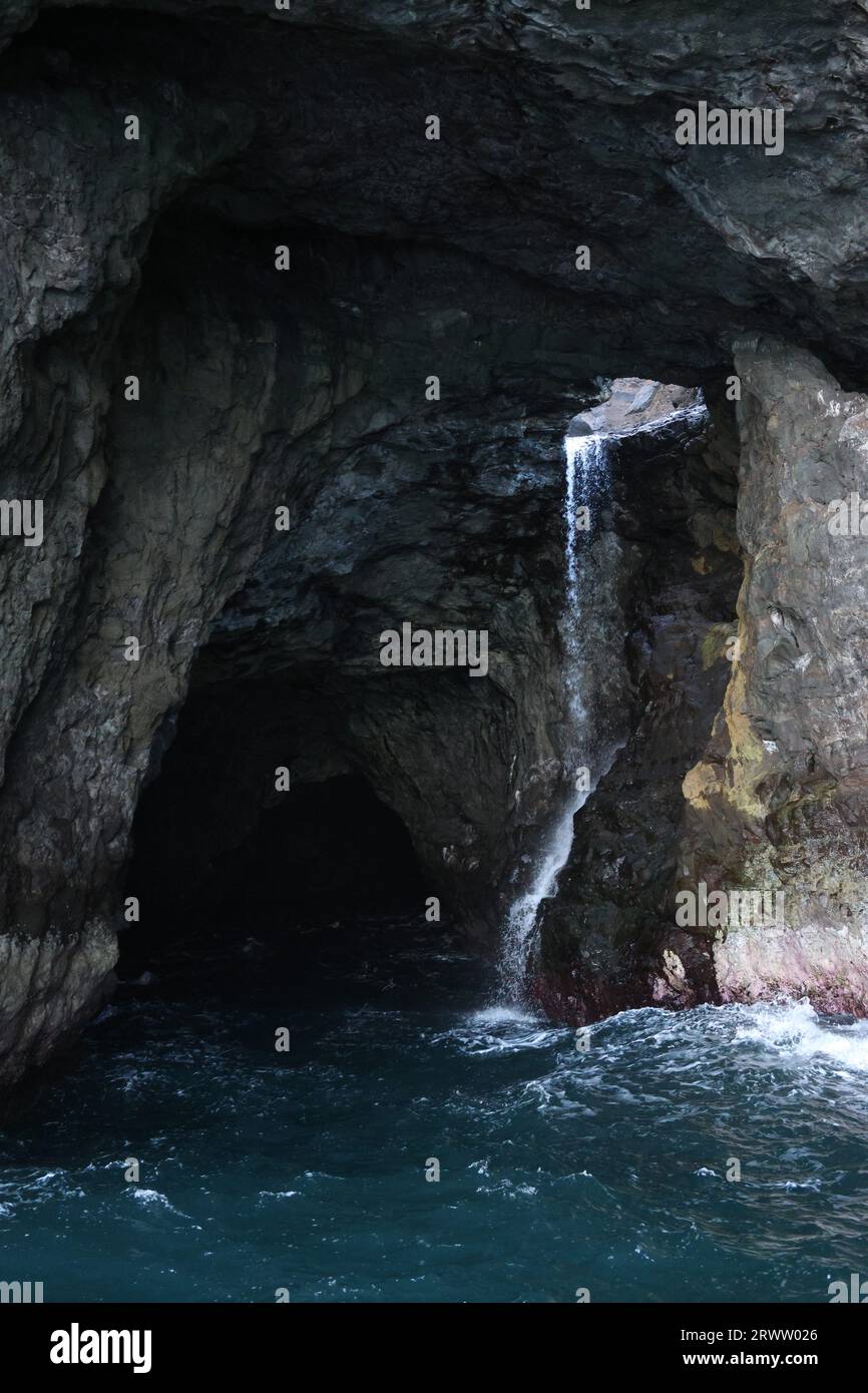 Une verticale d'une chute d'eau tombant en cascade sur une grotte rocheuse Banque D'Images