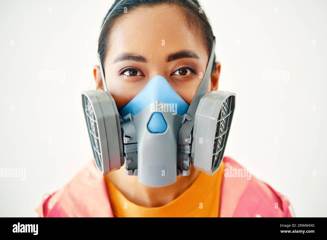 Gros plan portrait de jeune femme dans le masque respiratoire protecteur regardant la caméra sur fond blanc. Concept de pollution Banque D'Images