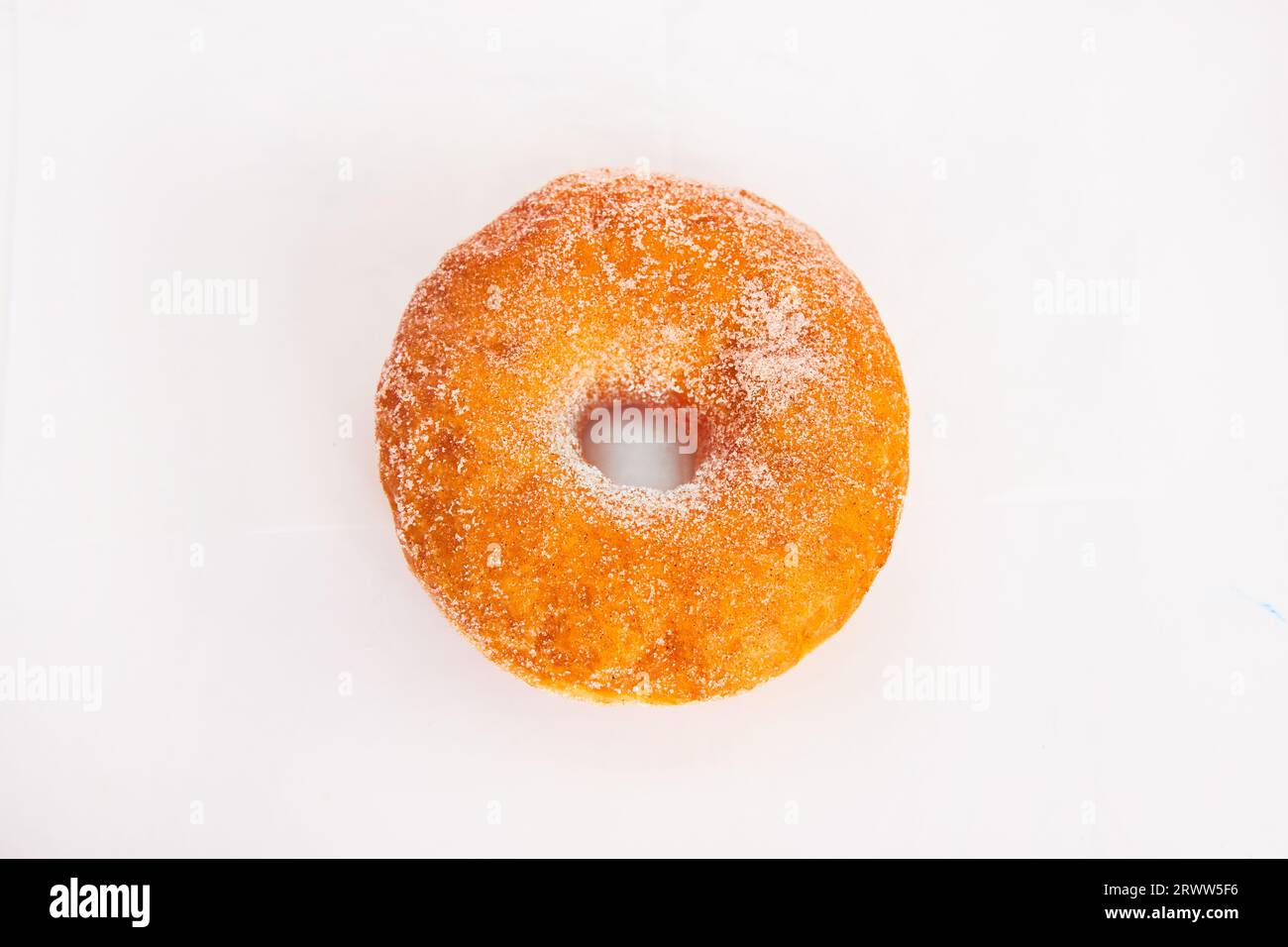 Beignet enrobé de sucre granulé sur fond blanc vue droite vers le bas Banque D'Images