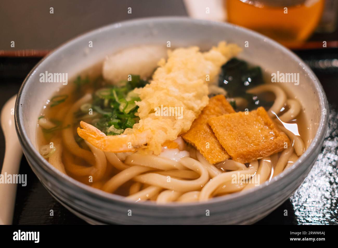 Un gros plan d'un bol avec soupe d'udon japonaise dans un restaurant, prêt à manger Banque D'Images