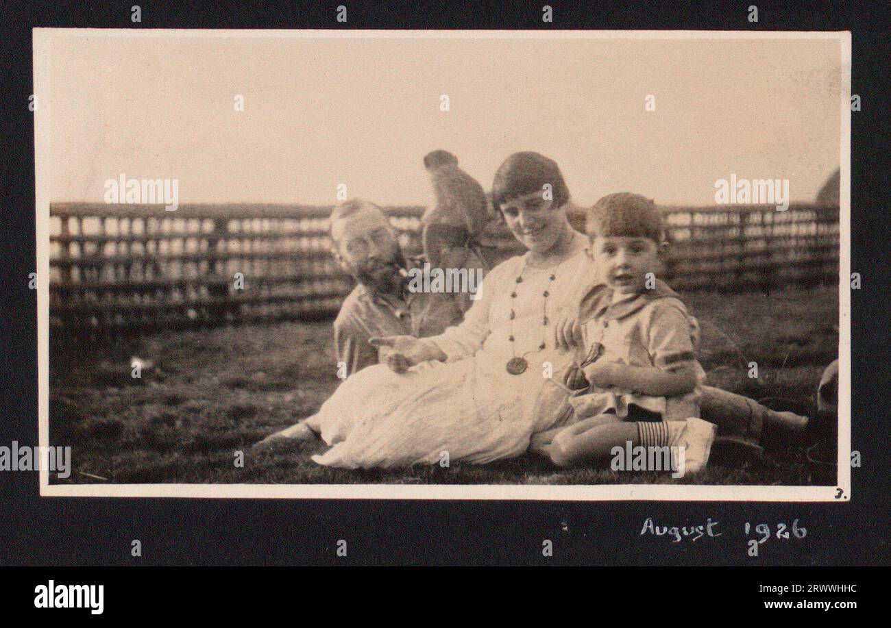 Portrait de famille informel de Margaret et James Maitland Trotter se détendant sur l'herbe avec leur fils Charles âgé de 3 ans et le singe Marmaduke. Banque D'Images