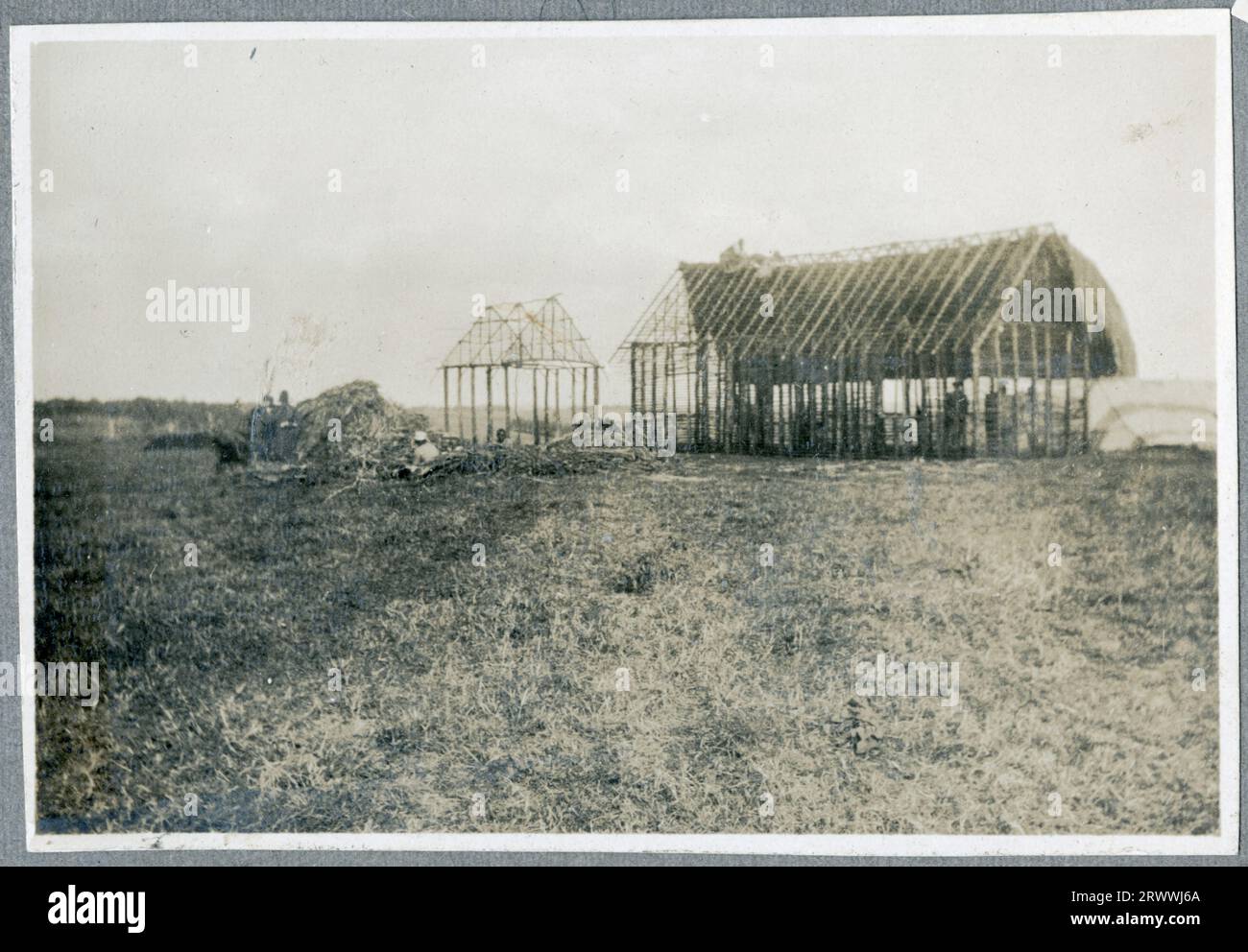 L'une des huit photos de la construction de 4 maisons en chaume à ossature de bois et d'un atelier pour le Native Industrial Training Depot où Charles Bungey était instructeur technique en chef. Cette photo montre un bâtiment long, bas, en chaume. Le grillage est à travers les fenêtres et les murs sont faits de poteaux en bois. Légende originale du manuscrit : quartiers des élèves N. I. T.D. Kabete. 1924, atelier temporaire N.I.T.D. 1924. Banque D'Images