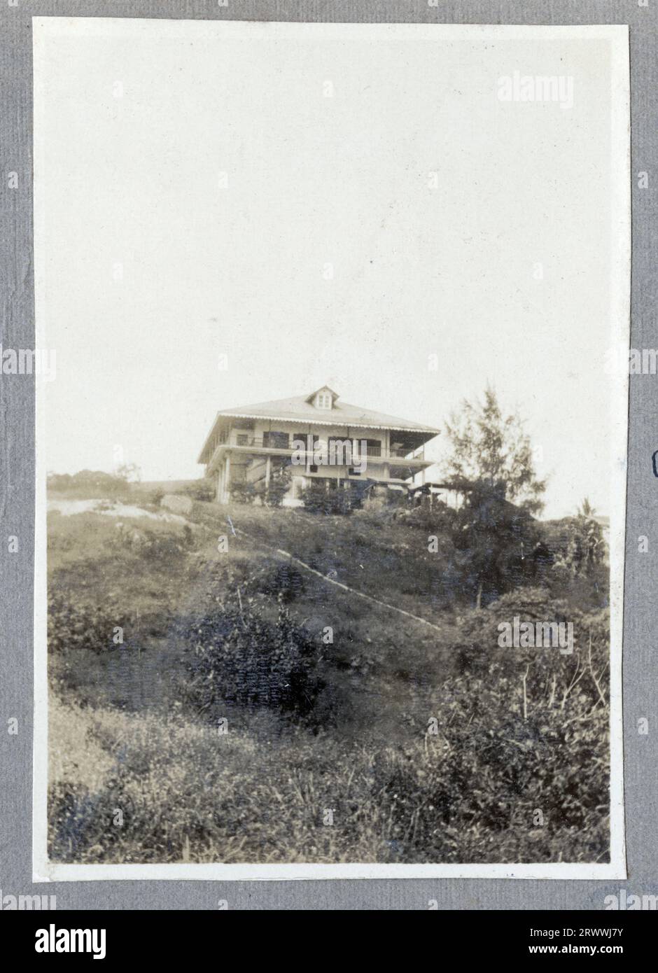 Vue lointaine d'un navire à vapeur à double entonnoir à l'ancre, vu de l'autre côté de l'eau. Légende originale du manuscrit : S.S. Bellatrix, port de Kilindini. 1925. Banque D'Images