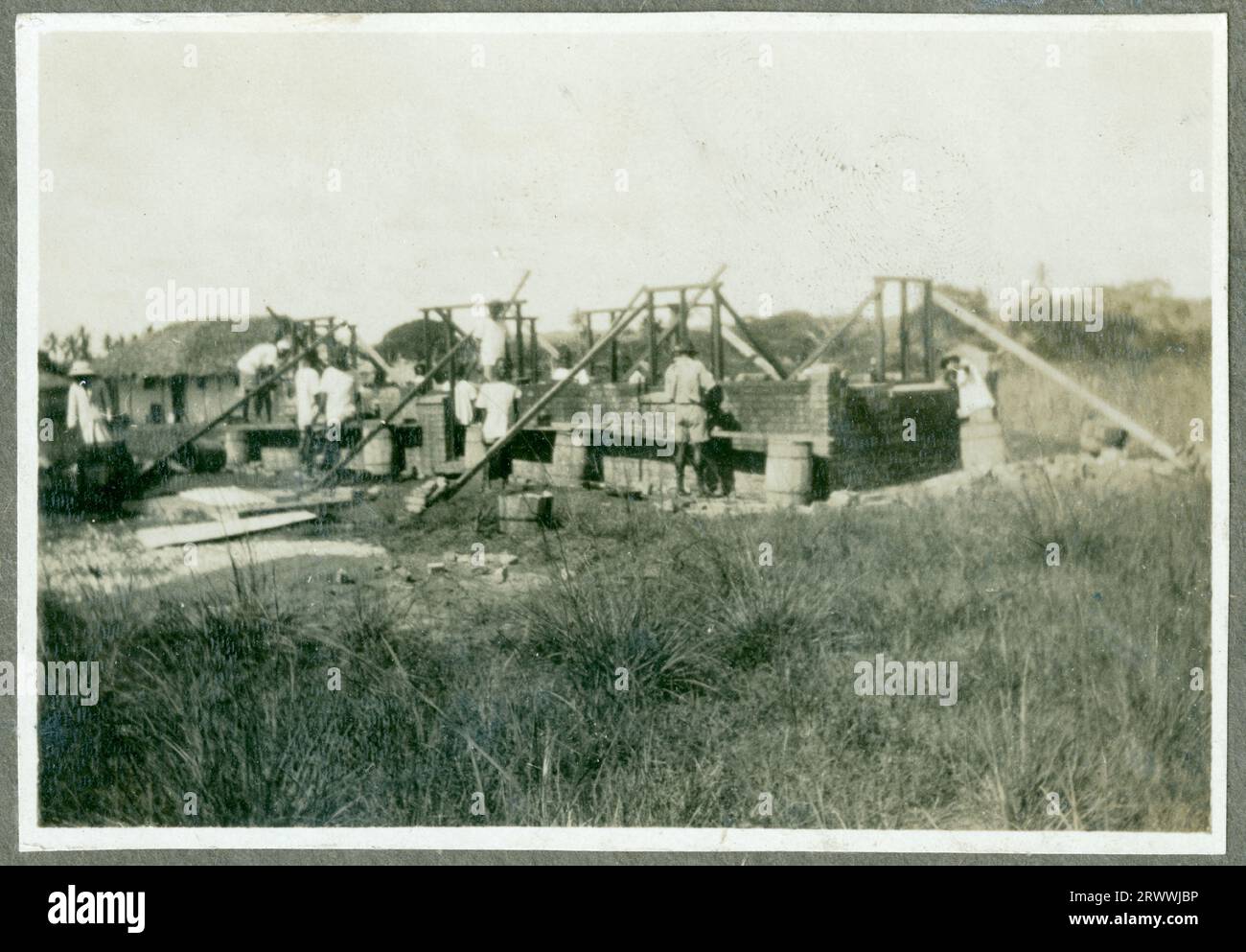 L'une des huit photos de la construction de 4 maisons en chaume à ossature de bois et d'un atelier pour le Native Industrial Training Depot où Charles Bungey était instructeur technique en chef. Cette photo montre un chariot à bœufs traversant la plaine. Deux bovins sont attachés ensemble et tirent un chariot à roues hautes conduit par un homme africain. Légende originale du manuscrit : quartiers des élèves N. I. T.D. Kabete. 1924. Banque D'Images