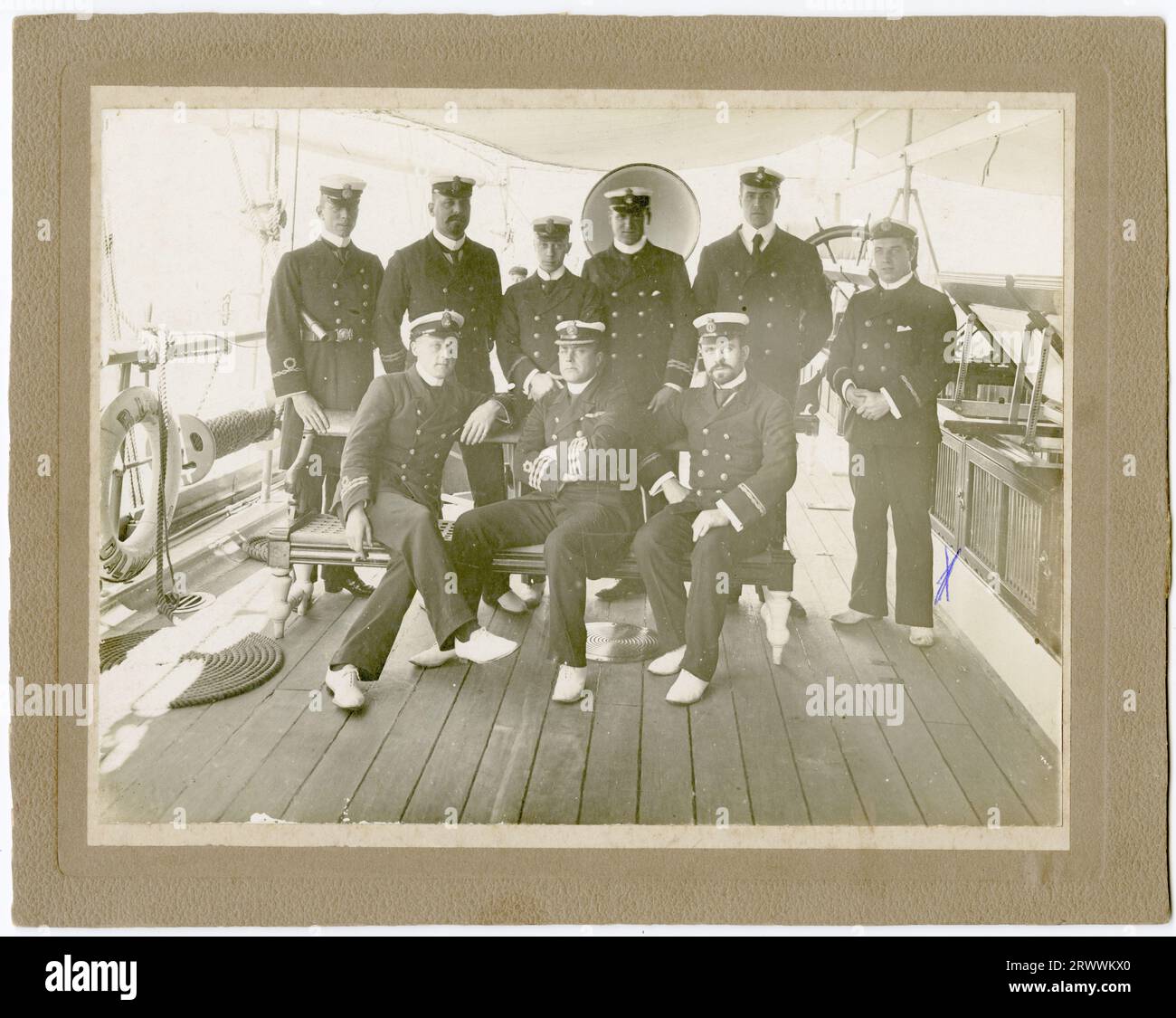 Photographie portrait, prise sur le pont d'un navire, d'un groupe d'officiers de navire en uniforme. Mentionné au dos de la photo comme provenant de la Royal Indian Navy, mais le nom du navire n'est pas donné. George Ellis Wood est indiqué par un X sur le côté droit de la photo. La légende au verso se lit comme suit : G E Wood Royal Indian Navy (1st R debout) vers 1900. Banque D'Images