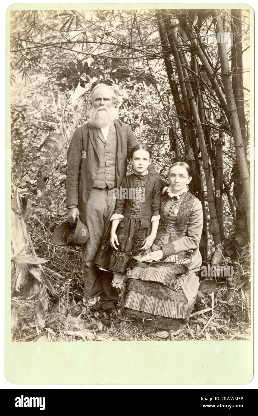 Le groupe pose pour la photo devant une plante de bambou, avec John Small et Lizzie debout, et Eliza assise. Small tient un casque de moelle dans sa main. Imprimé au verso : H L Duperly, photographe, Jamaïque. Banque D'Images