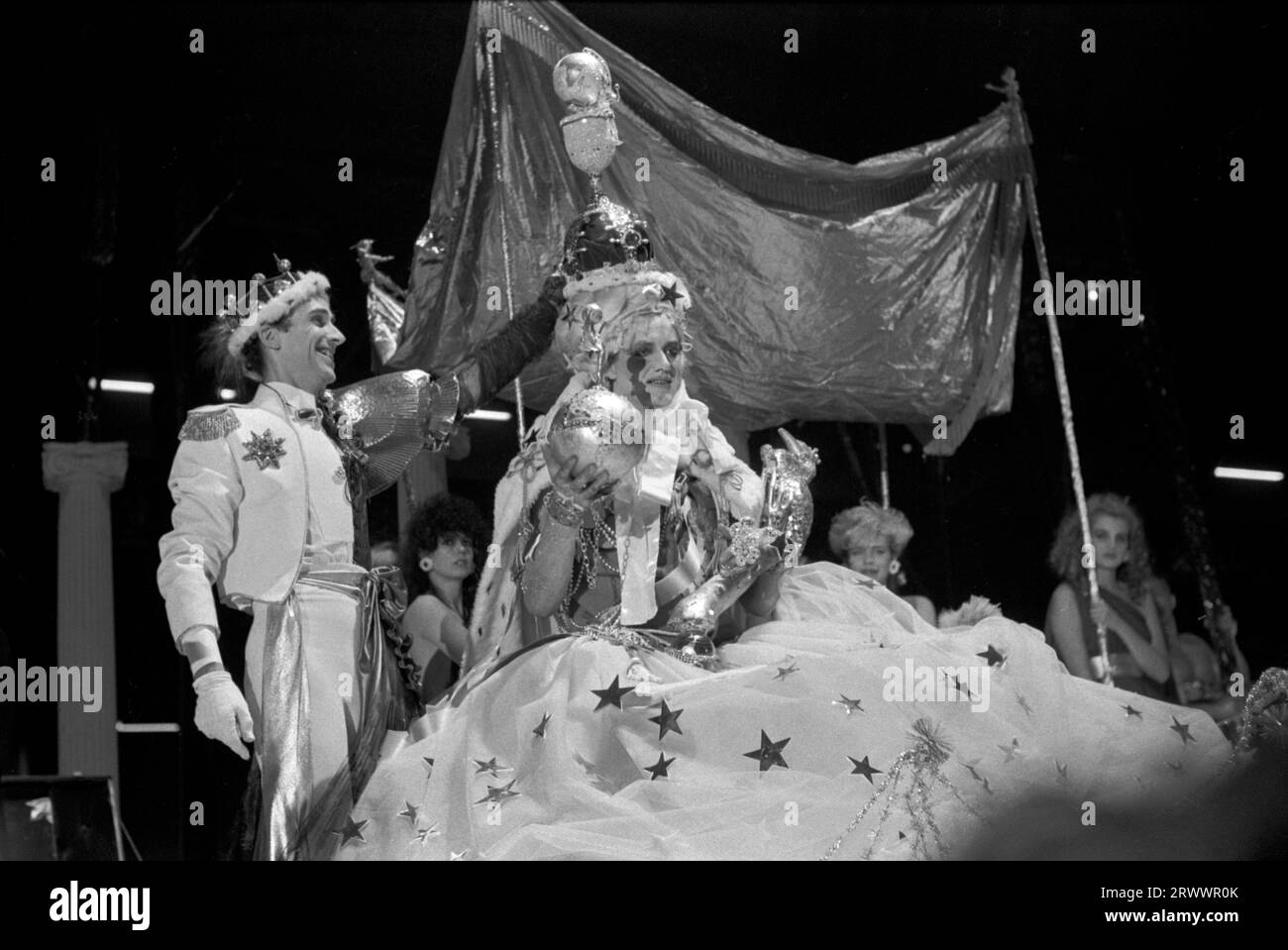 Andrew Logan, artiste et organisateur du concours de concours de beauté alternative Miss World. Vu ici avec la gagnante Miss Aldershot - Michael Haynes , couronnant lui - elle est la gagnante de la 5e compétition. Haynes tient une boule ornée de bijoux dans sa main droite et un sceptre de paon, sceptre, symbole d'autorité dans sa main gauche. Grand Hall, Olympia, West London Angleterre 1981. ANNÉES 1980 ROYAUME-UNI HOMER SYKES Banque D'Images