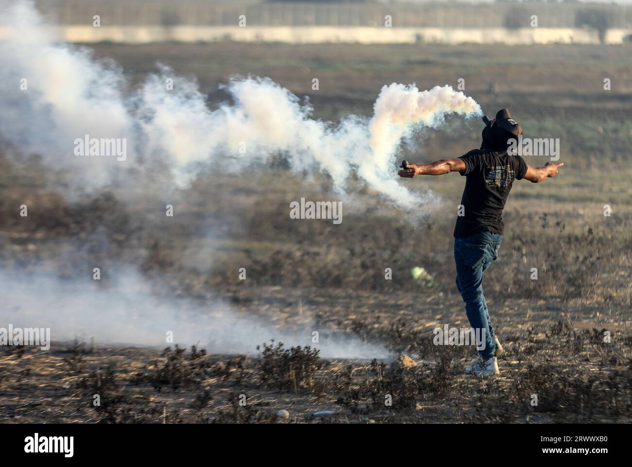 18 septembre 2023, Gaza, Palestine : un manifestant palestinien tient une bombe à gaz dans sa bouche lors d’affrontements avec les forces de sécurité israéliennes le long de la clôture séparant Gaza et Israël, à l’est de la ville de Gaza. (Image de crédit : © Yousef Masoud/SOPA Images via ZUMA Press Wire) USAGE ÉDITORIAL SEULEMENT! Non destiné à UN USAGE commercial ! Banque D'Images