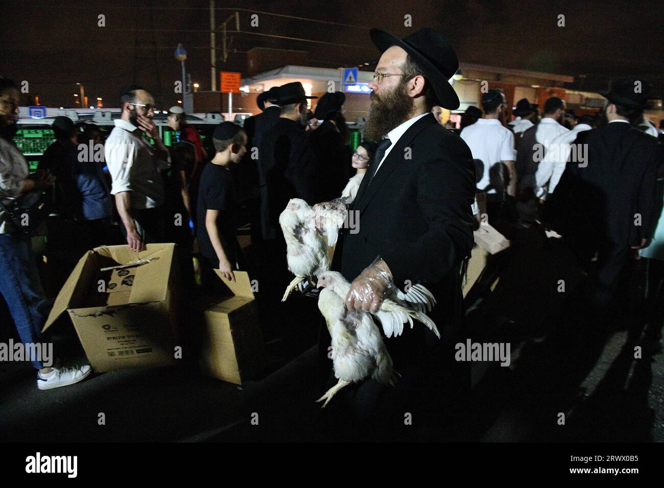 (230921) -- BNEI BRAK, 21 septembre 2023 (Xinhua) -- des Juifs ultra orthodoxes exécutent la cérémonie du Kaparot, où des poulets blancs sont abattus comme geste symbolique d'expiation avant Yom Kippour, le jour juif des expiations, à Bnei Brak, une banlieue de tel Aviv, Israël, le 20 septembre 2023. (JINI via Xinhua) Banque D'Images