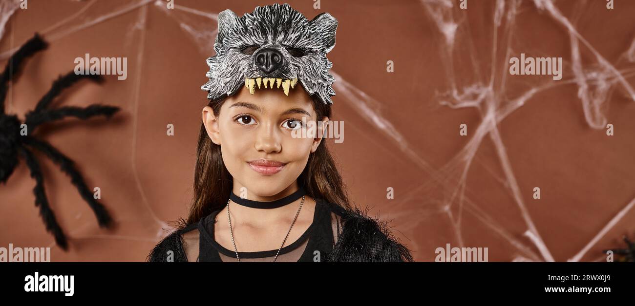 Souriante fille de préadolescence sur fond brun avec araignée noire sur Halloween, gros plan, bannière Banque D'Images