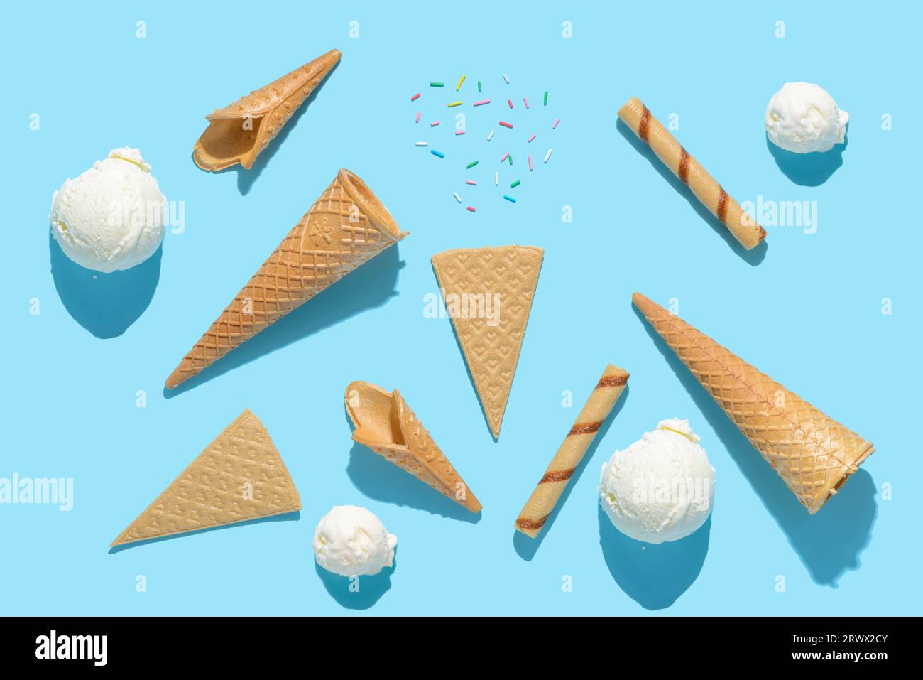 vue de dessus boules de cône de crème glacée, saupoudreuses, cigares et ventilateurs sur bleu avec ombre dure, concept d'été. Banque D'Images