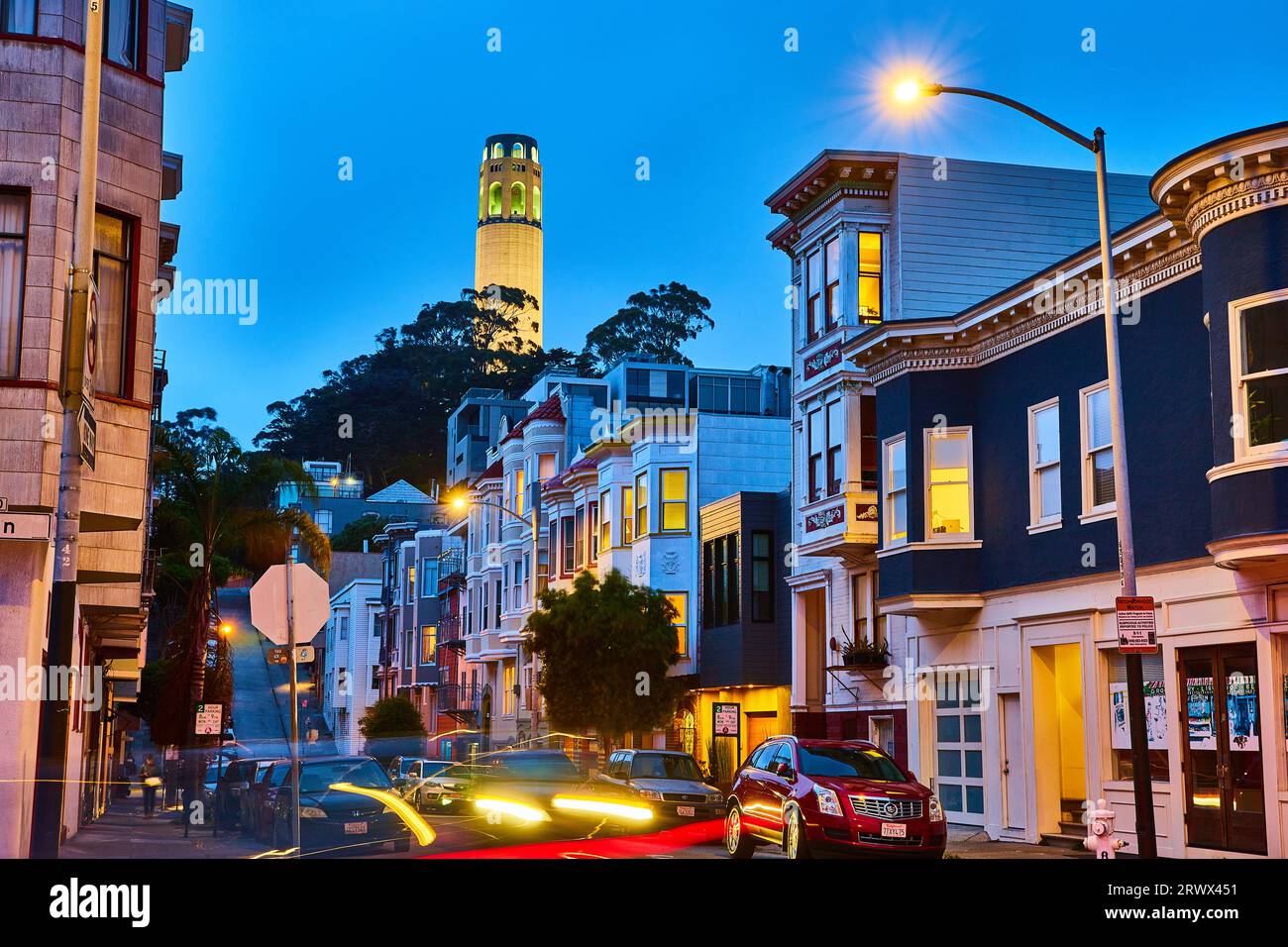 Vue nocturne sur la rue californienne illuminée de voitures floues et de Coit Tower Banque D'Images