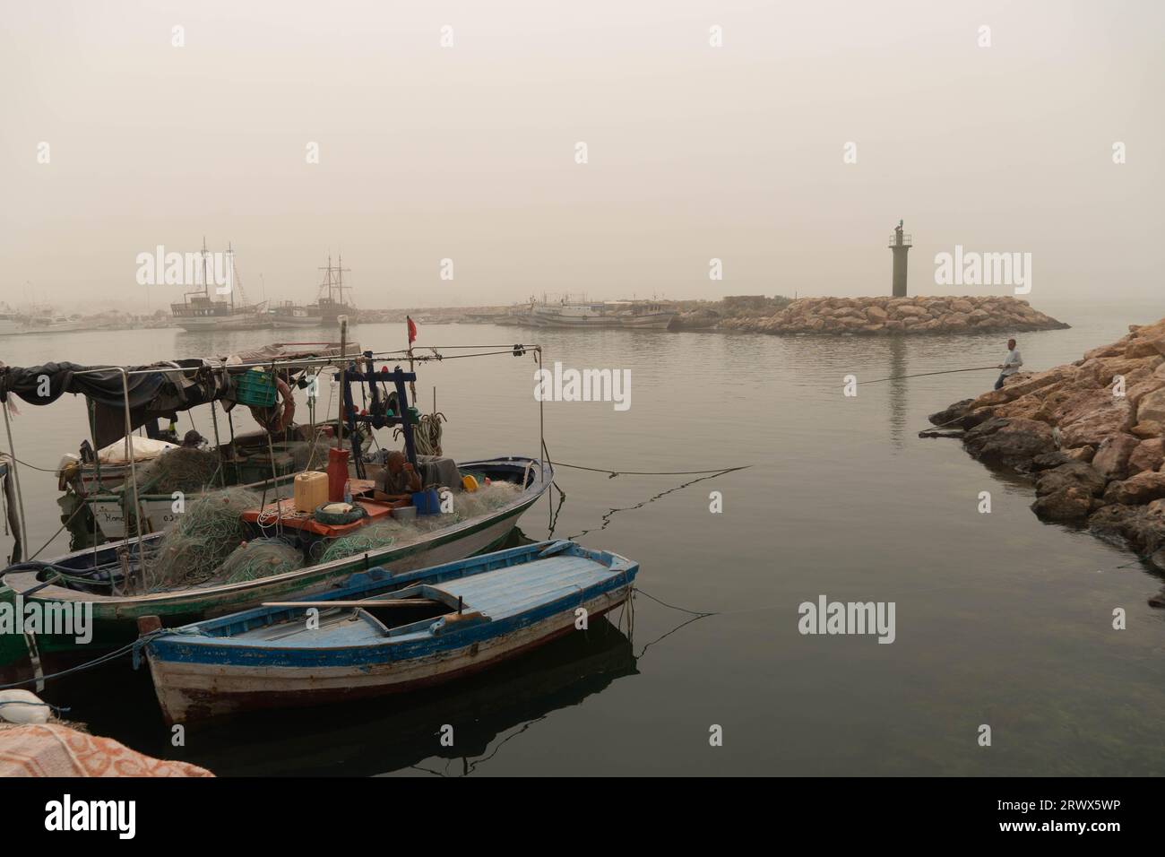 Le port de Djerba après la tempête de sable avec les bateaux de pêche et de crabe au premier plan. Banque D'Images