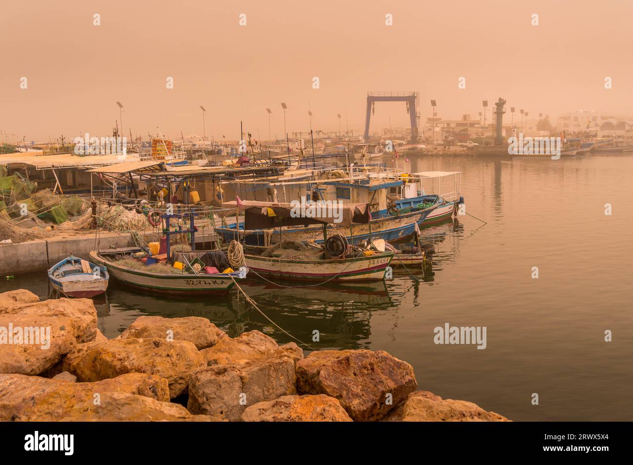 Le port de Djerba après la tempête de sable avec les bateaux de pêche et de crabe au premier plan. Banque D'Images