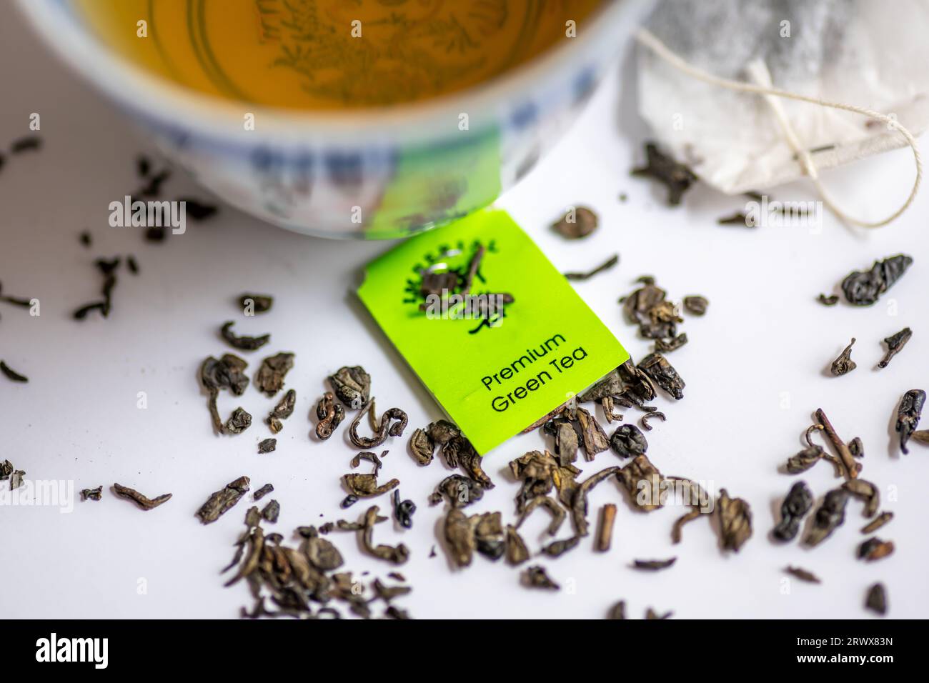 Feuilles de thé vert en vrac et sachets de thé avec une tasse de thé vert isolé en blanc. Boisson santé, concept de mode de vie sain. Banque D'Images