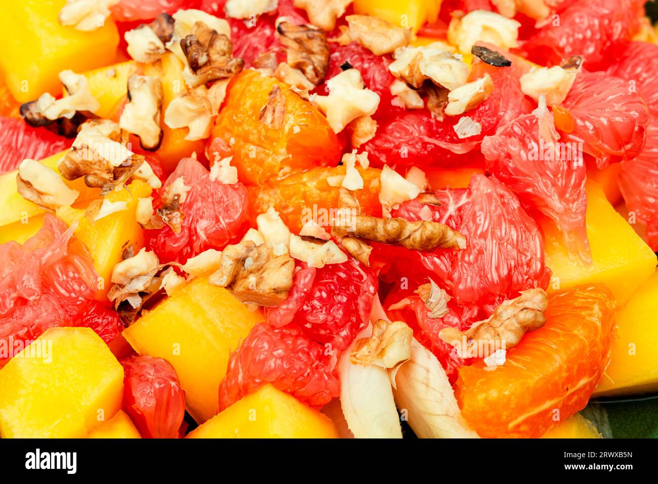 Délicieuse salade vitaminée de pamplemousse, de mangue, de noix et de chicorée. Gros plan Banque D'Images
