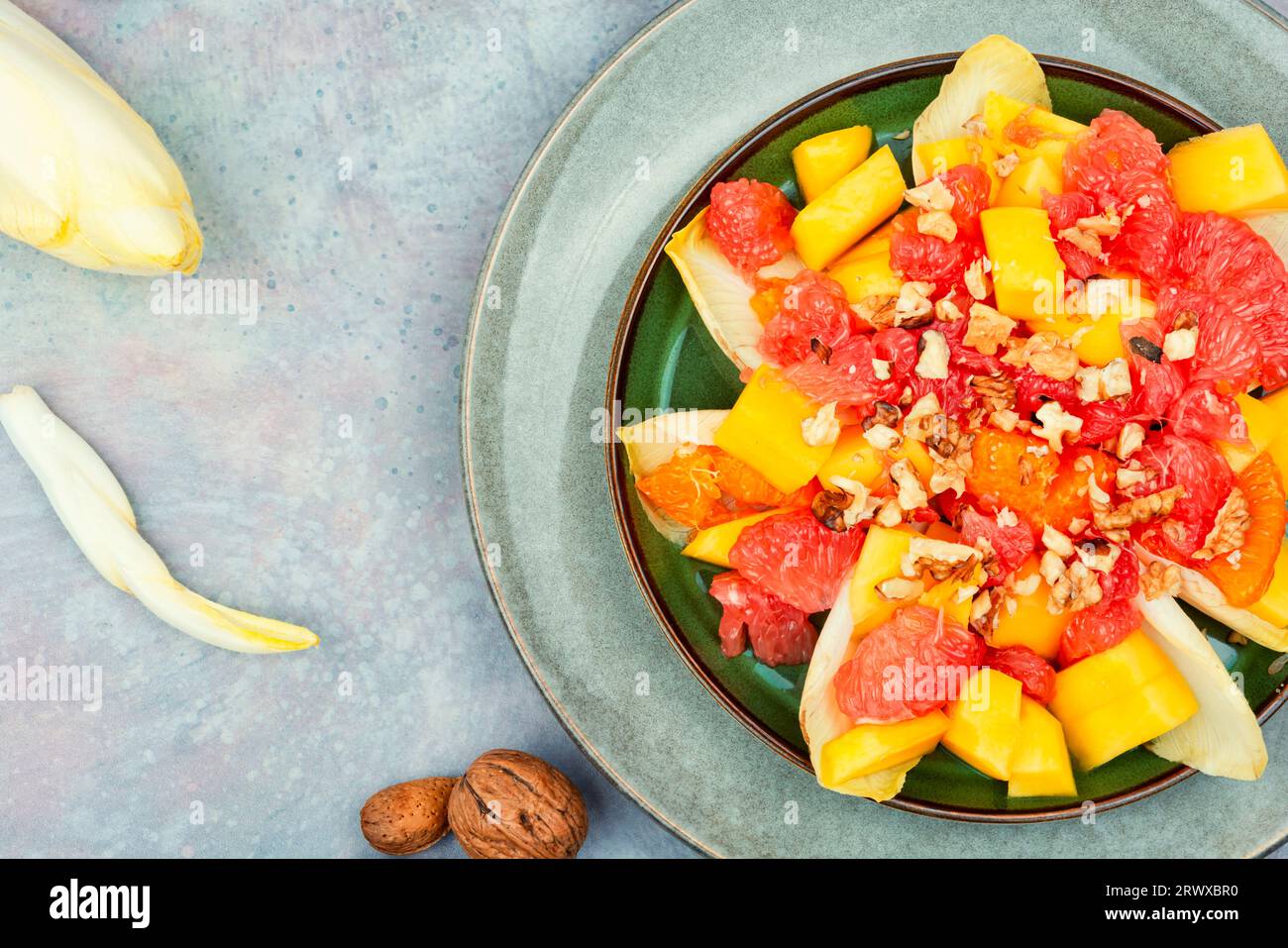 Délicieuse salade vitaminée de pamplemousse, de mangue, de noix et de chicorée. Espace pour le texte Banque D'Images