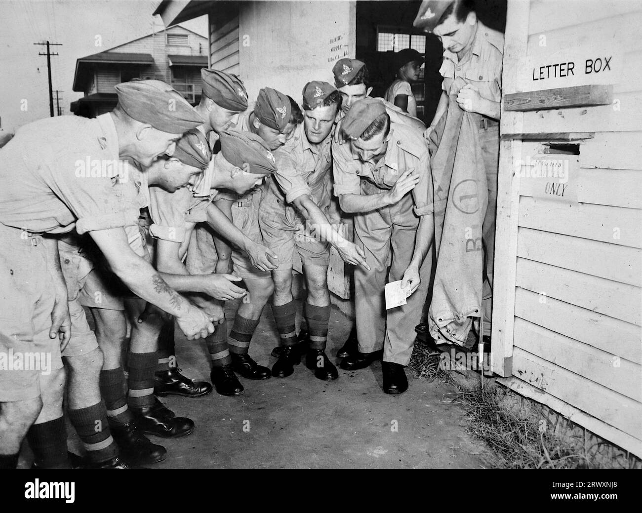 Un groupe de personnel à l'extérieur d'un bureau de courrier, l'emplacement n'est pas clair. Rare photographie provenant d'une collection compilée par un militaire britannique inconnu couvrant la démonstration composite n°1, batterie AA, tournée des Etats-Unis, du 11 juillet 1943. Il s'agit d'une parmi plus d'une centaine d'images de la collection qui étaient en moyenne autour de 4x3 pouces. Banque D'Images