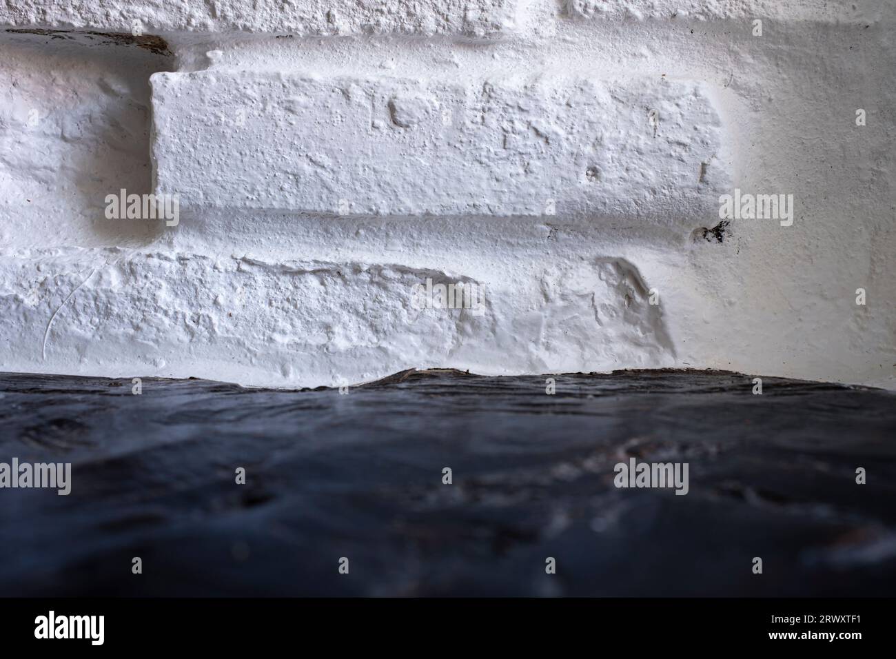 Fond de brique peint blanc avec texture et premier plan de bois sombre flou. Arrière-plans et modèles conceptuels. Banque D'Images
