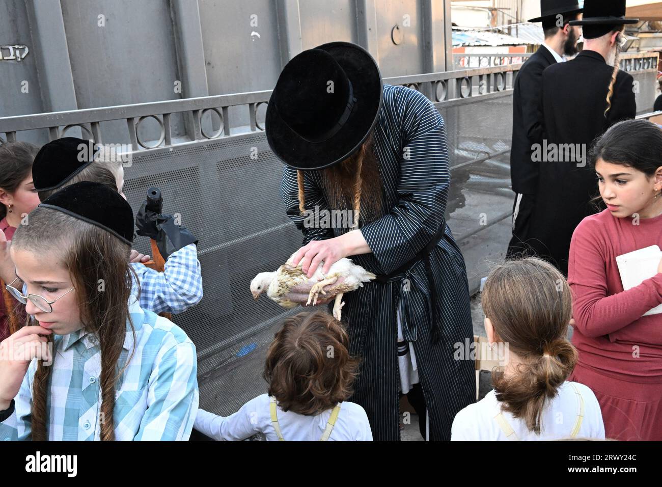 Jérusalem, Israël. 21 septembre 2023. Un juif ultra-orthodoxe montre aux enfants un poulet qui sera utilisé dans l’ancien rituel Kapparot à Mea Shearim à Jérusalem, le jeudi 21 septembre 2023. Kapparot est préformé avant Yom Kippour, le jour des Expiations, le jour le plus sacré du calendrier juif, et transfère symboliquement les péchés de l'année passée au poulet. Photo de Debbie Hill/ crédit : UPI/Alamy Live News Banque D'Images