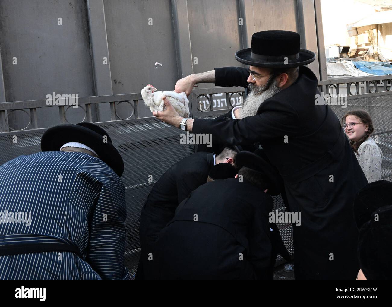 Jérusalem, Israël. 21 septembre 2023. Un juif ultra-orthodoxe balançait une poule au-dessus des têtes d'hommes lors de l'ancien rituel Kapparot à Mea Shearim à Jérusalem, le jeudi 21 septembre 2023. Kapparot est préformé avant Yom Kippour, le jour des Expiations, le jour le plus sacré du calendrier juif, et transfère symboliquement les péchés de l'année passée au poulet. Photo de Debbie Hill/ crédit : UPI/Alamy Live News Banque D'Images
