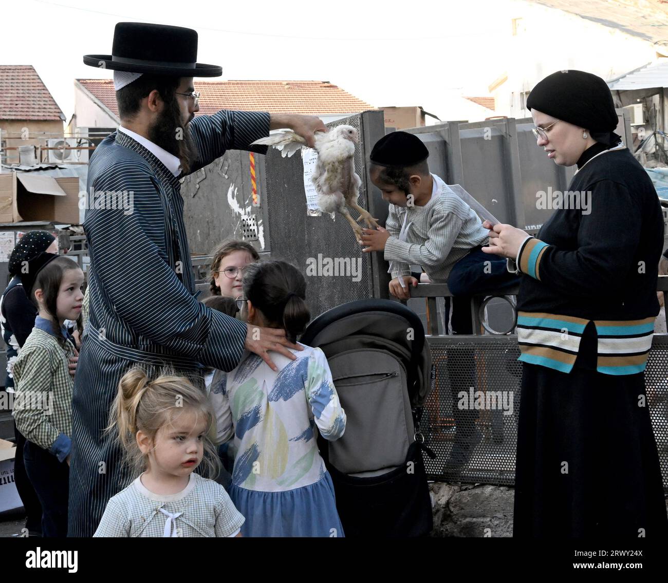 Jérusalem, Israël. 21 septembre 2023. Un juif ultra-orthodoxe balançait un poulet sur la tête de ses enfants lors de l'ancien rituel Kapparot à Mea Shearim à Jérusalem, le jeudi 21 septembre 2023. Kapparot est préformé avant Yom Kippour, le jour des Expiations, le jour le plus sacré du calendrier juif, et transfère symboliquement les péchés de l'année passée au poulet. Photo de Debbie Hill/ crédit : UPI/Alamy Live News Banque D'Images