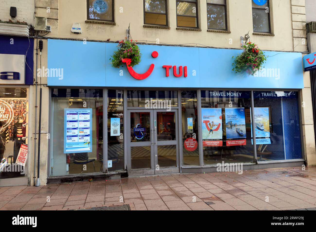 Les agents de voyage TUI se mettent à l'avant avec des paniers de fleurs suspendus, Queen Street, Cardiff. Prise en septembre 2023 Banque D'Images