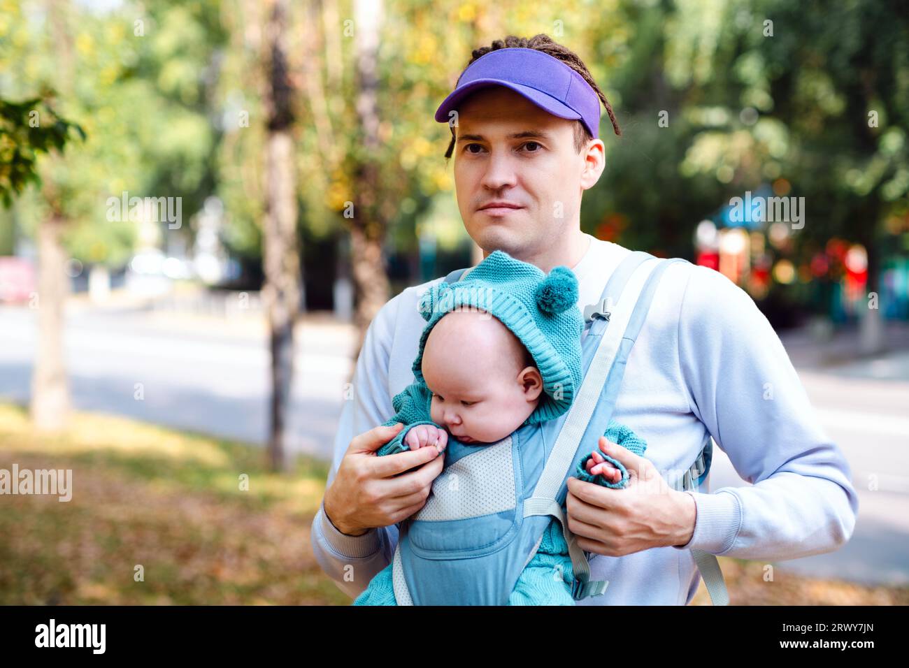 Jeune père avec son nouveau-né dans une écharpe dans le parc. Banque D'Images