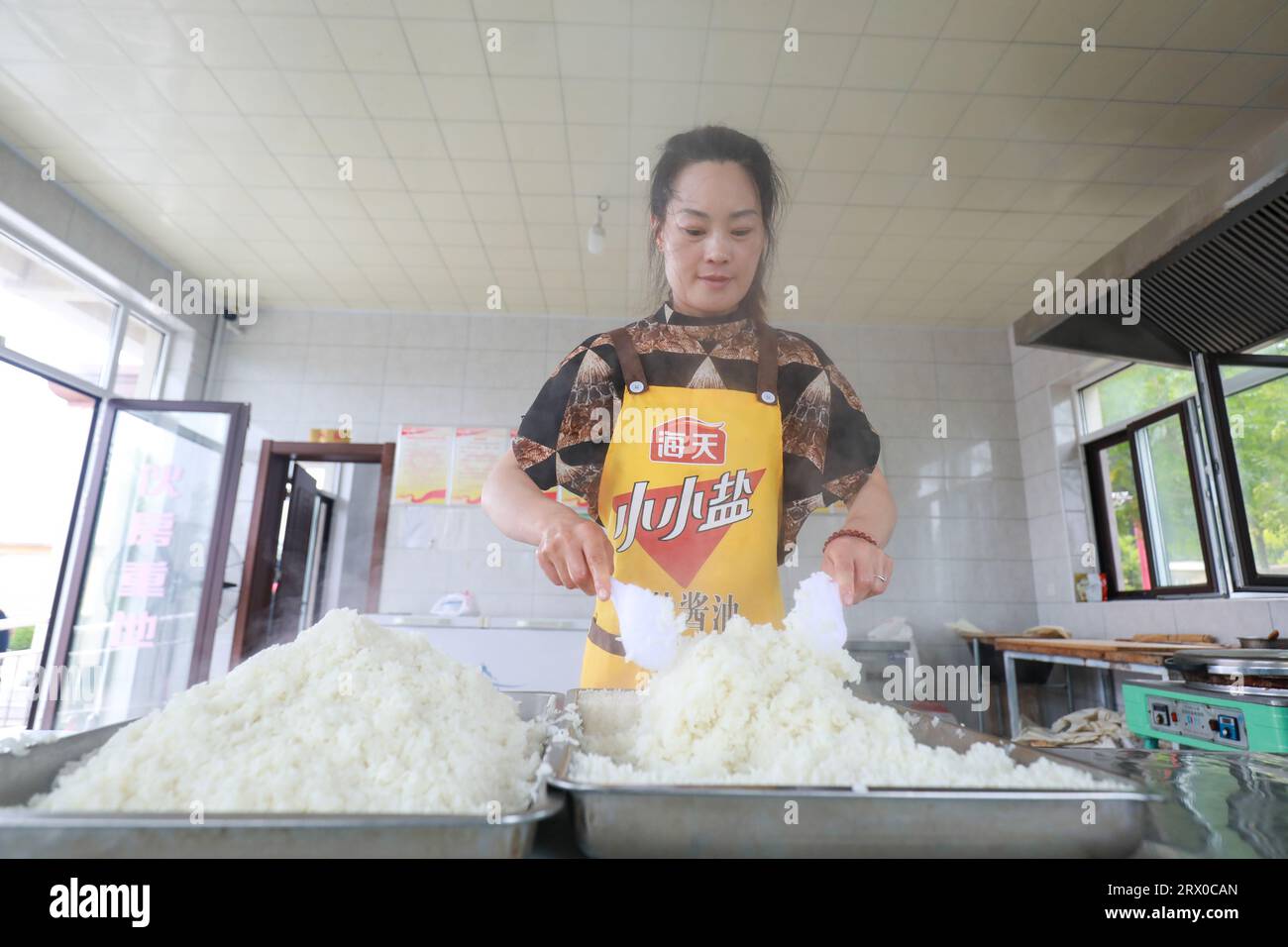 Comté de Luannan, Chine - 9 août 2023 : le personnel organise le riz et se prépare à servir les personnes âgées vivant seules dans une petite cafétéria. Banque D'Images