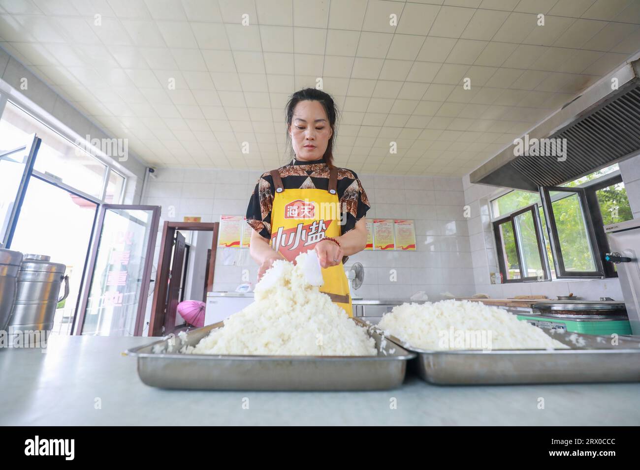 Comté de Luannan, Chine - 9 août 2023 : le personnel organise le riz et se prépare à servir les personnes âgées vivant seules dans une petite cafétéria. Banque D'Images