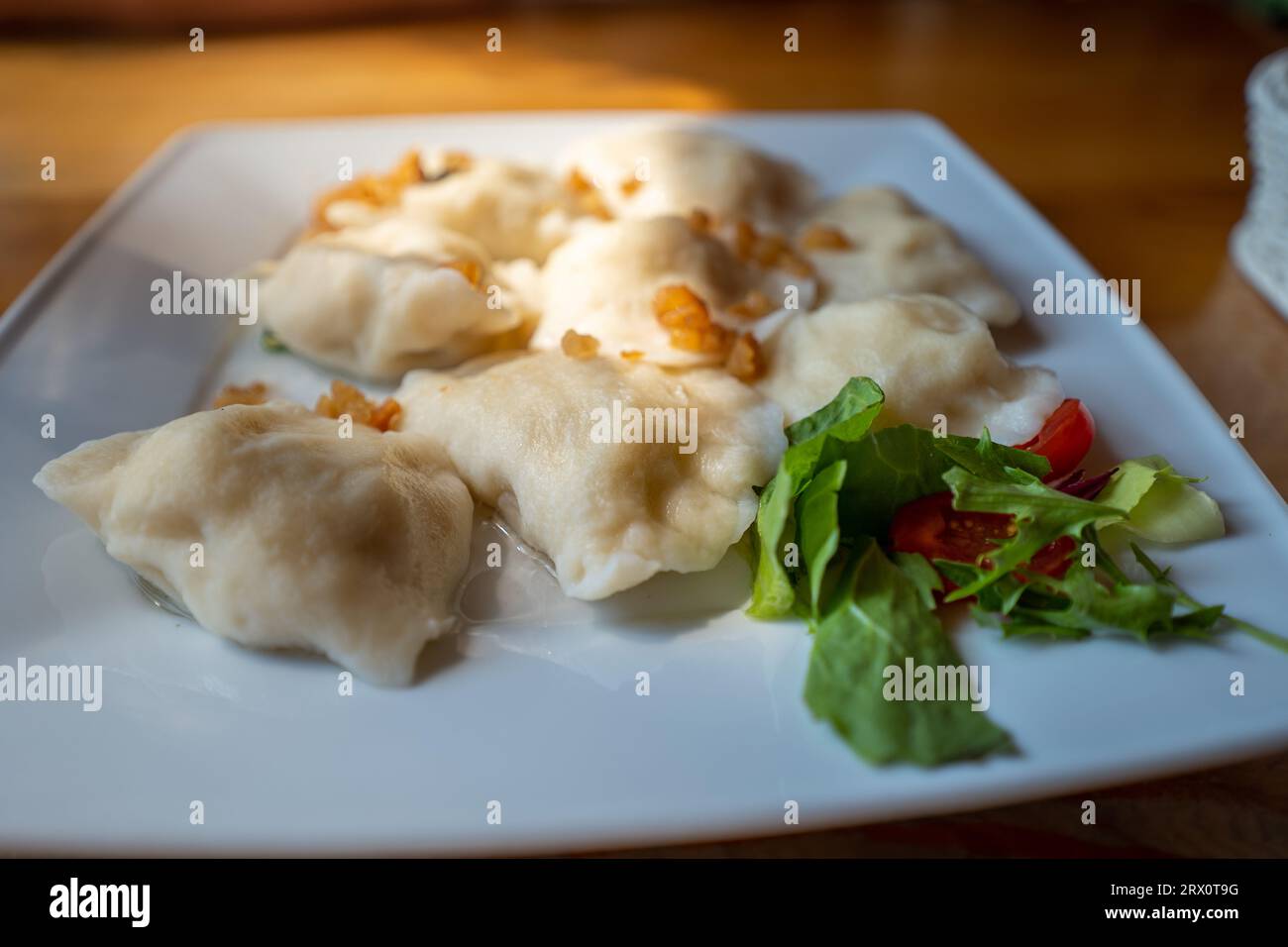 Une assiette pleine de boulettes garnies de craquelures. Lumière du soleil illuminant le plat. Plat polonais traditionnel. Banque D'Images