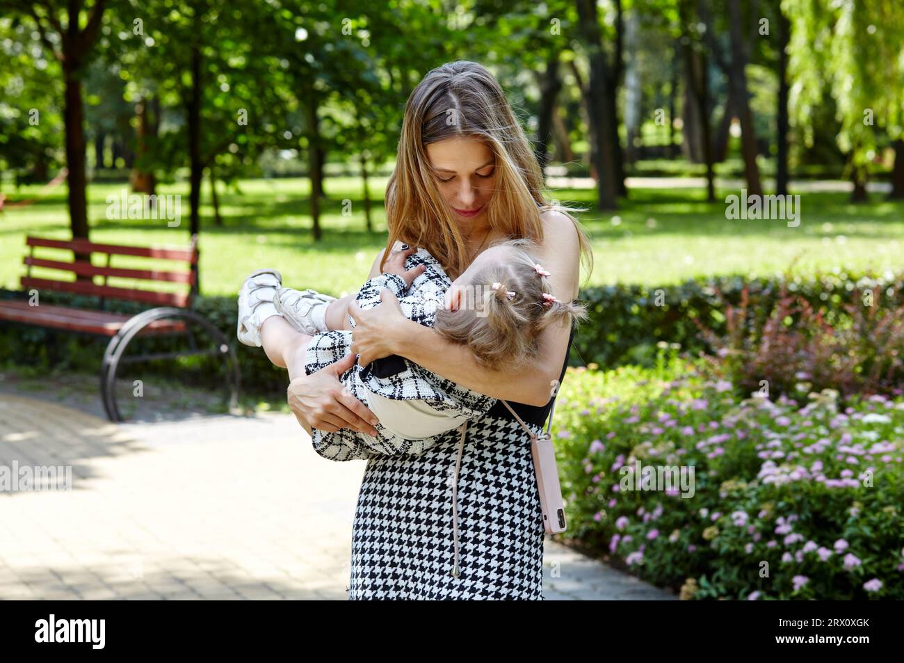 Mère et fille marchent dans le parc de la ville d'été. Enfance, loisirs et concept de personnes - famille heureuse repose sur la nature et passe un bon moment Banque D'Images