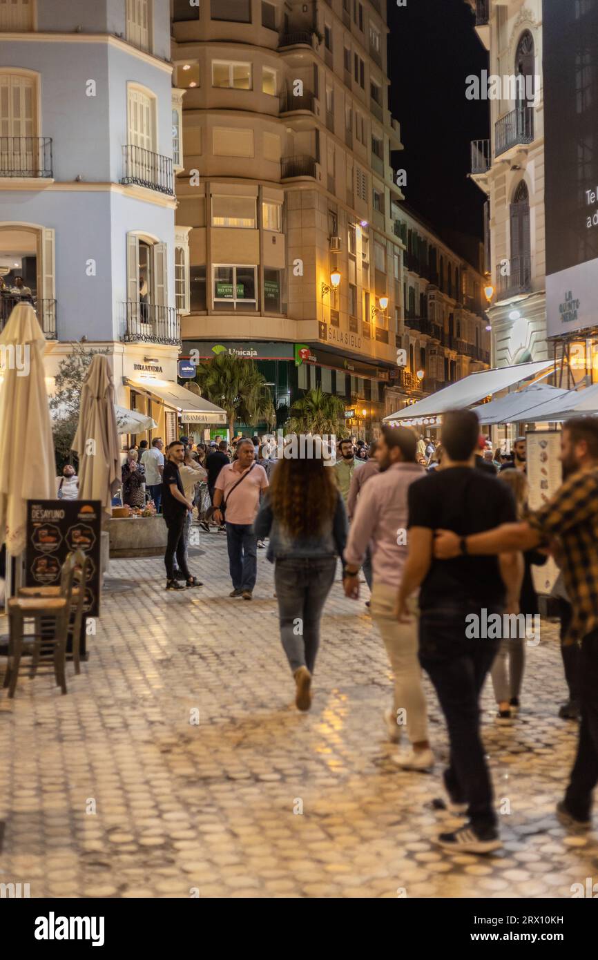 Malaga la nuit, vie nocturne dans les rues du vieux centre-ville. Des gens marchant, assis dans des restaurants, mangeant et buvant. Europe, Espagne. Banque D'Images