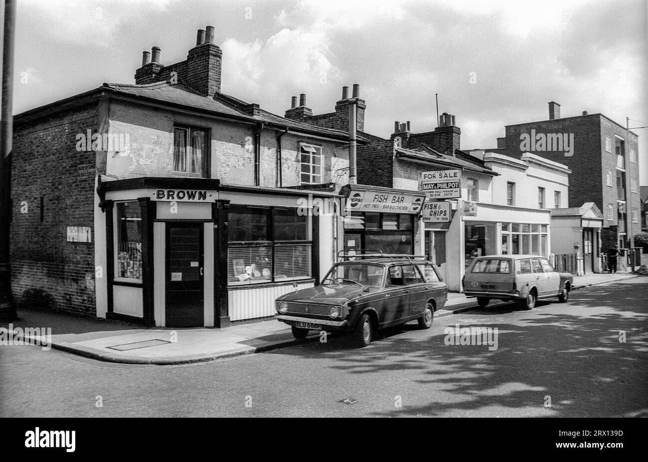 Photographie en noir et blanc d'archives de 1975 de magasins à l'angle de Crownstone Road et Brixton Water Lane à Lambeth, au sud de Londres. Depuis démoli. Banque D'Images