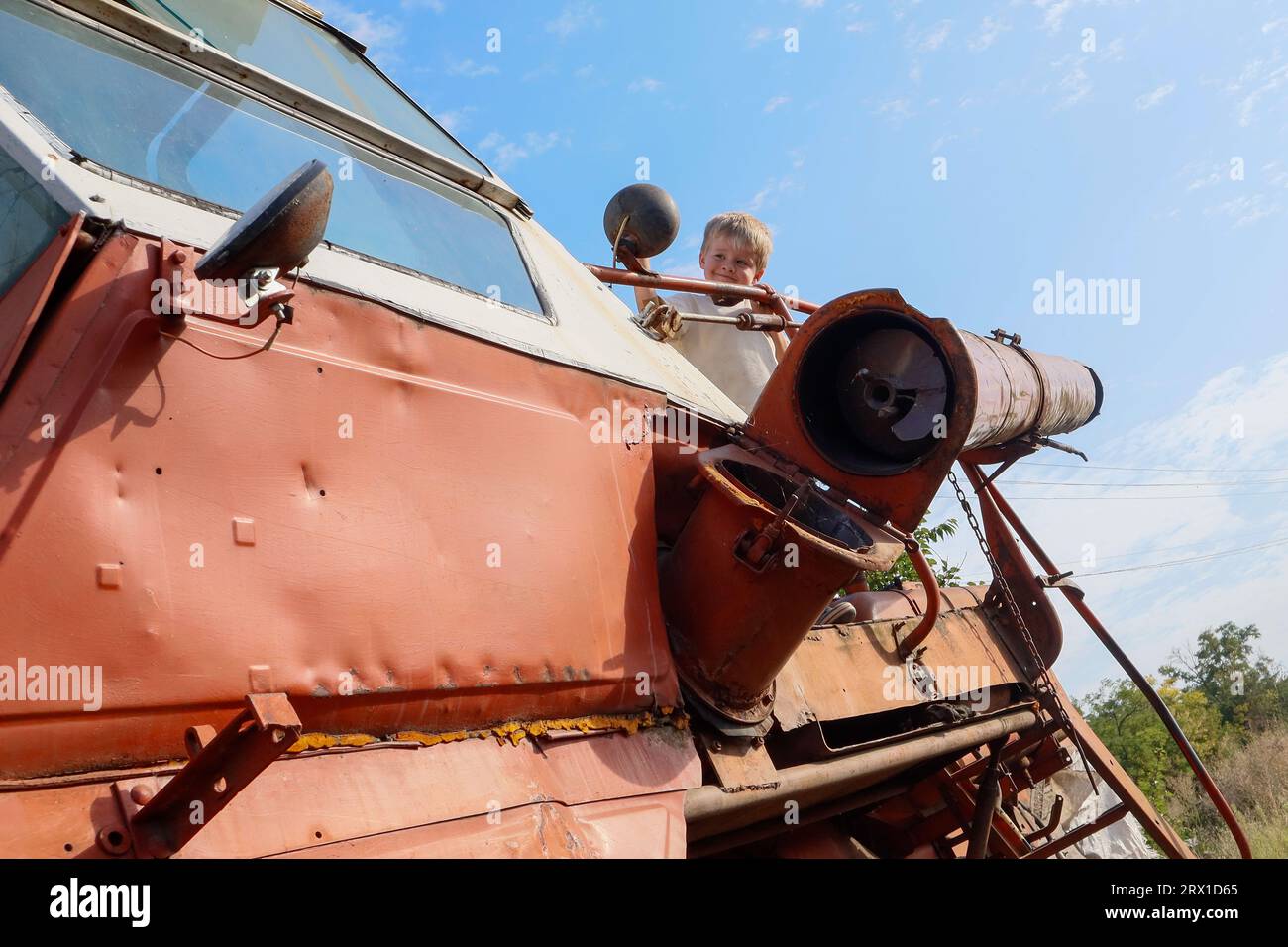 Un petit garçon blond dans un vieux gros Cartel Banque D'Images