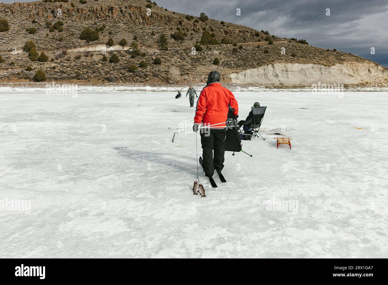 Famille sur le lac gelé dans les montagnes pêche sur glace et skis de fond Banque D'Images