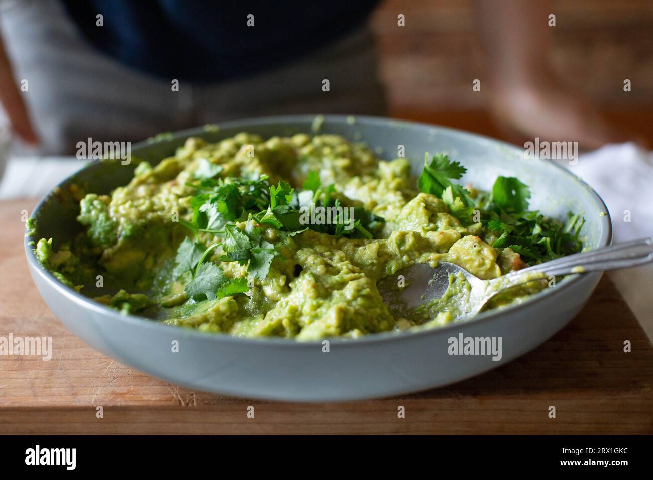 Guacamole fraîchement préparé dans un bol gris avec de la coriandre hachée Banque D'Images