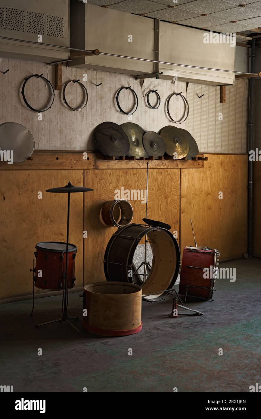 Un jeu de percussions incomplet abandonné dans une salle faiblement éclairée à Pyramiden, Svalbard Banque D'Images
