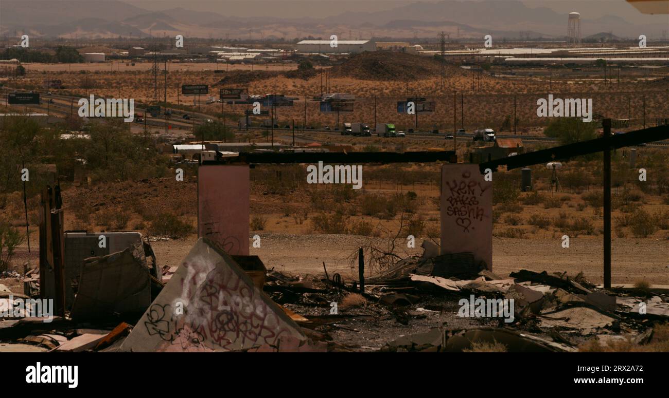 L'enveloppe grillée d'une station-service abandonnée avec un trafic autoroutier lourd scintille dans l'air chaud du désert à l'extérieur de Barstow, en Californie. Banque D'Images