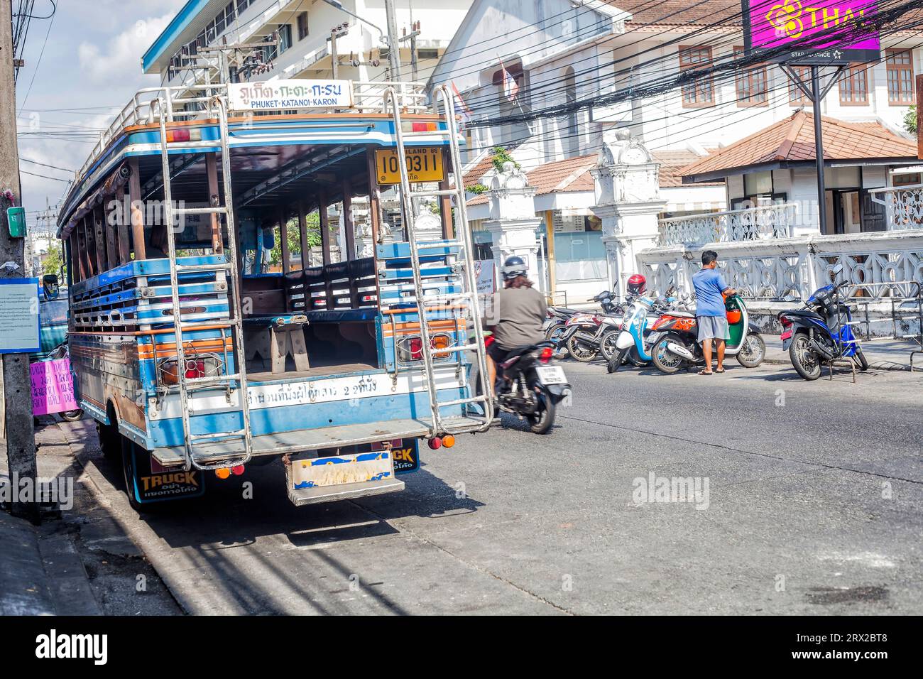 Phuket, Thaïlande - 26 février 2018 : rue avec bus, motocyclistes et population locale Banque D'Images