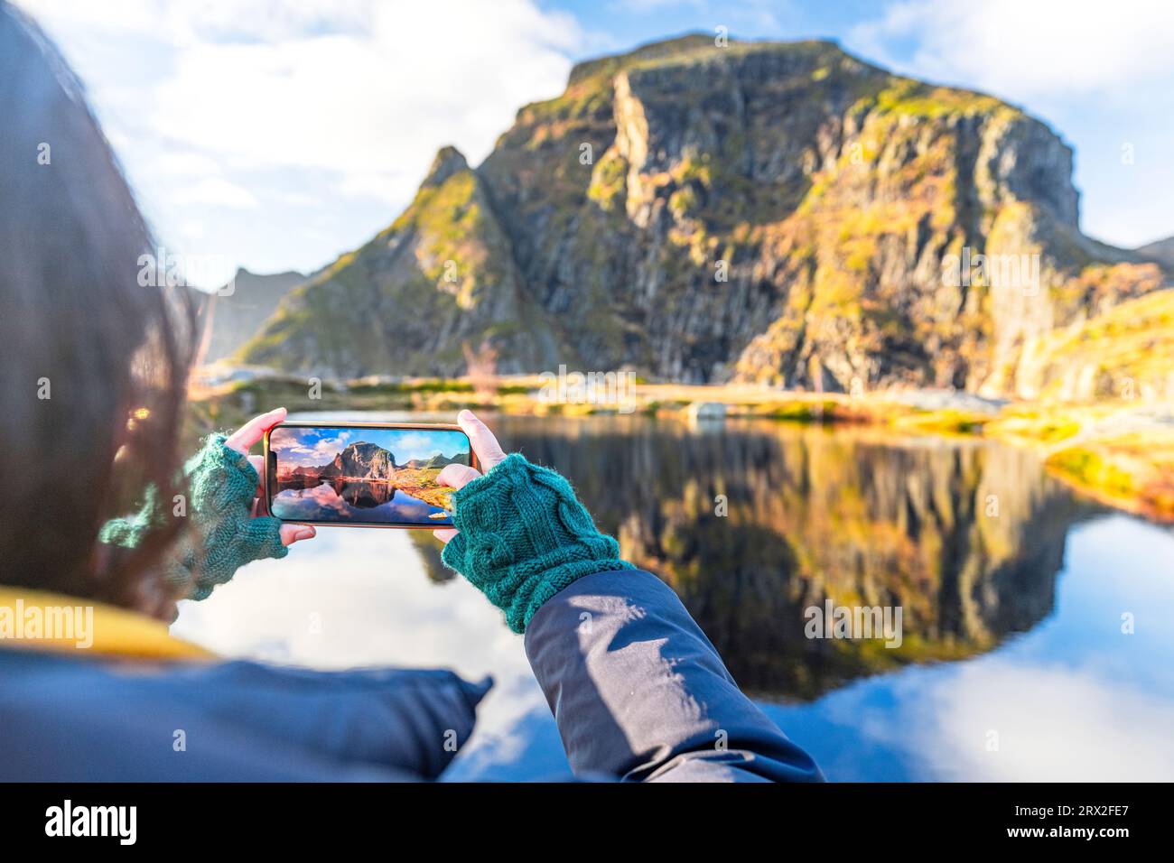 Perspective personnelle de femme photographiant des montagnes en automne avec smartphone, A i Lofoten, Moskenes, îles Lofoten, Nordland, Norvège, Scandinavie Banque D'Images