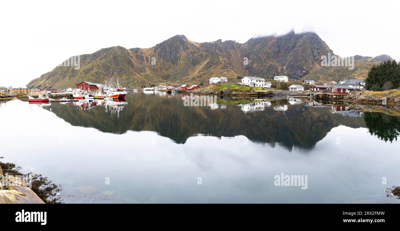 Village de pêcheurs de Ballstad et montagnes reflétées dans les eaux calmes d'un fjord, Vestvagoy, îles Lofoten, Nordland, Norvège, Scandinavie, Europe Banque D'Images