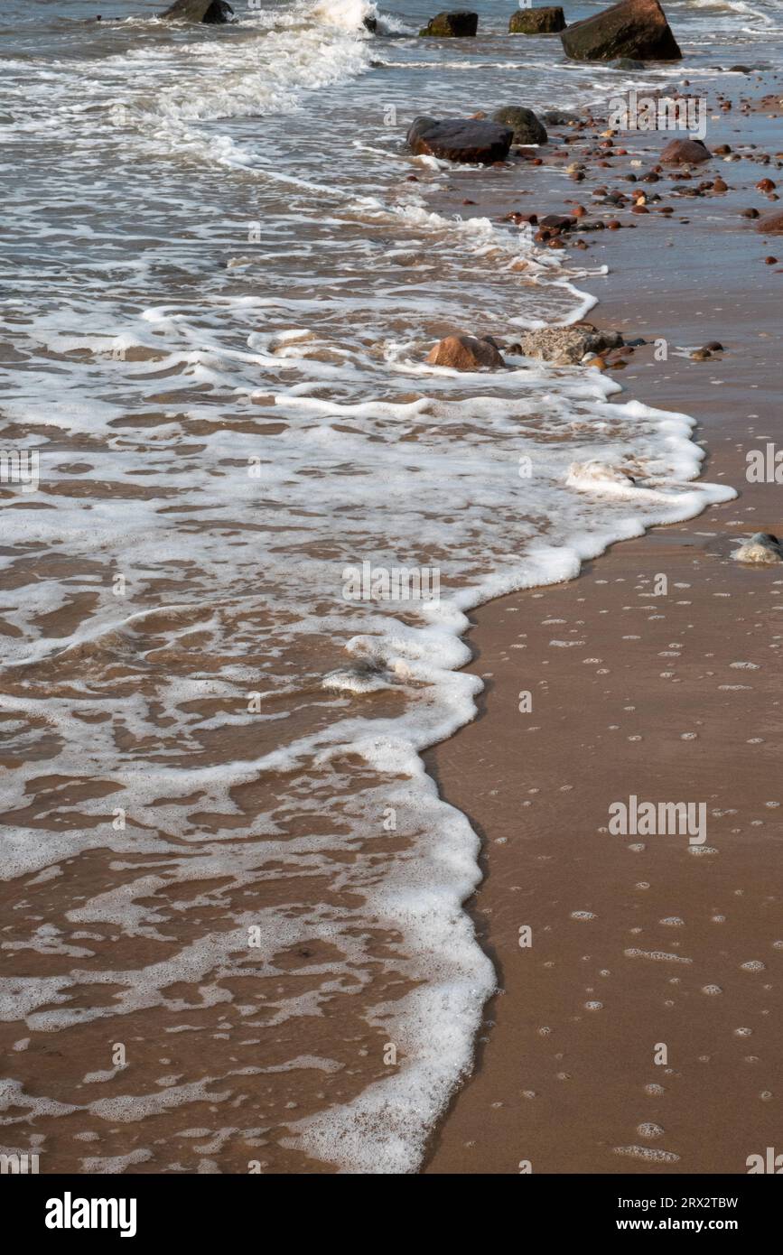 vagues de mer mousseuses rochers plage Banque D'Images