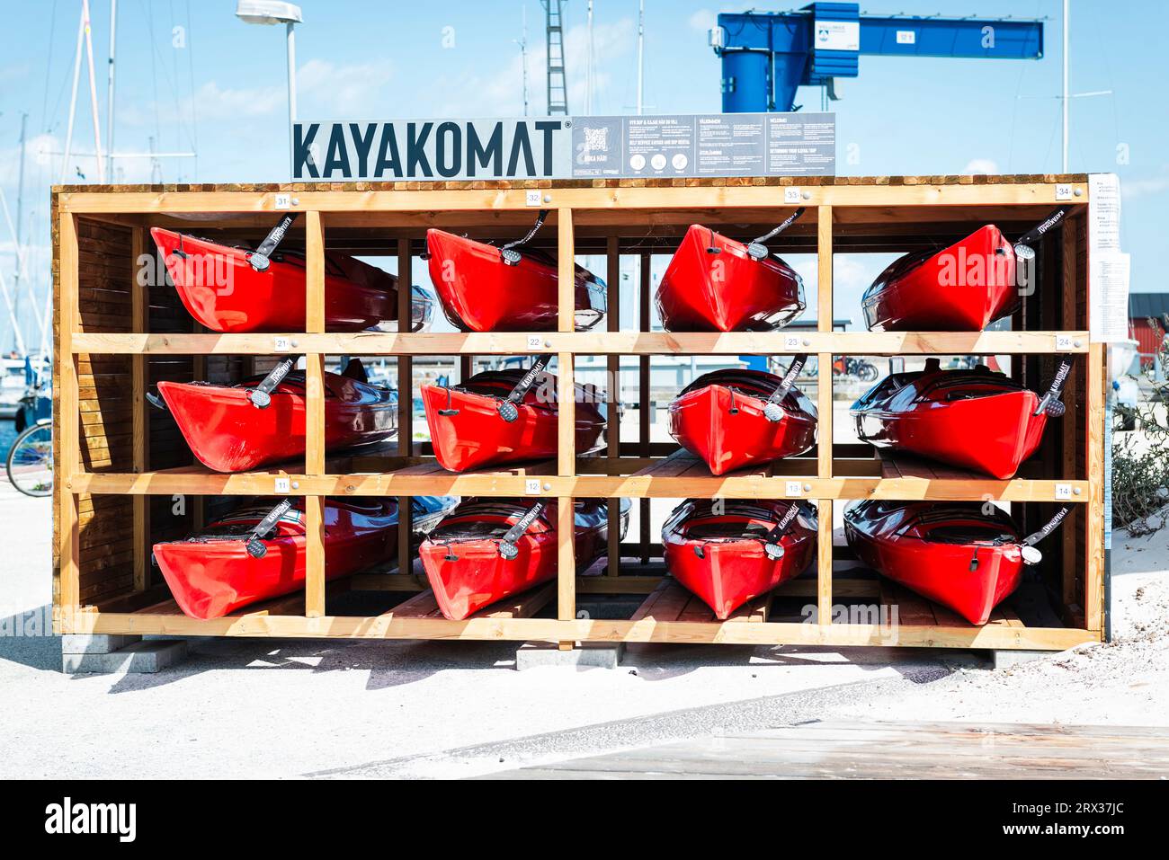 Kayakomat - rack en bois avec douze kayaks rouges à louer dans le port de Skkanör med Falsterbo, Skåne, Suède Banque D'Images