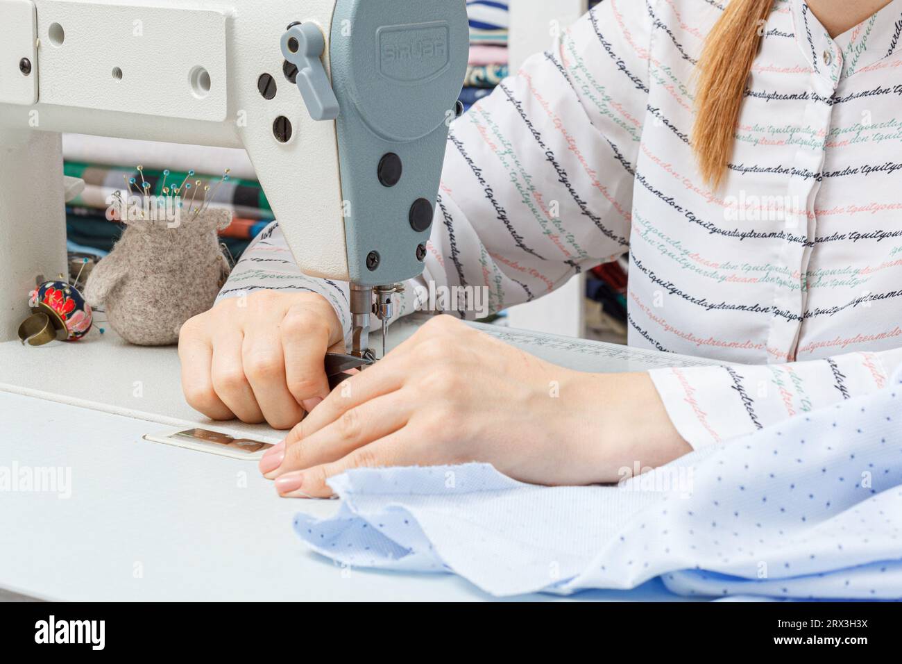 Les mains féminines d'un maître tailleur au travail, une aiguille de machine à coudre gros plan Banque D'Images