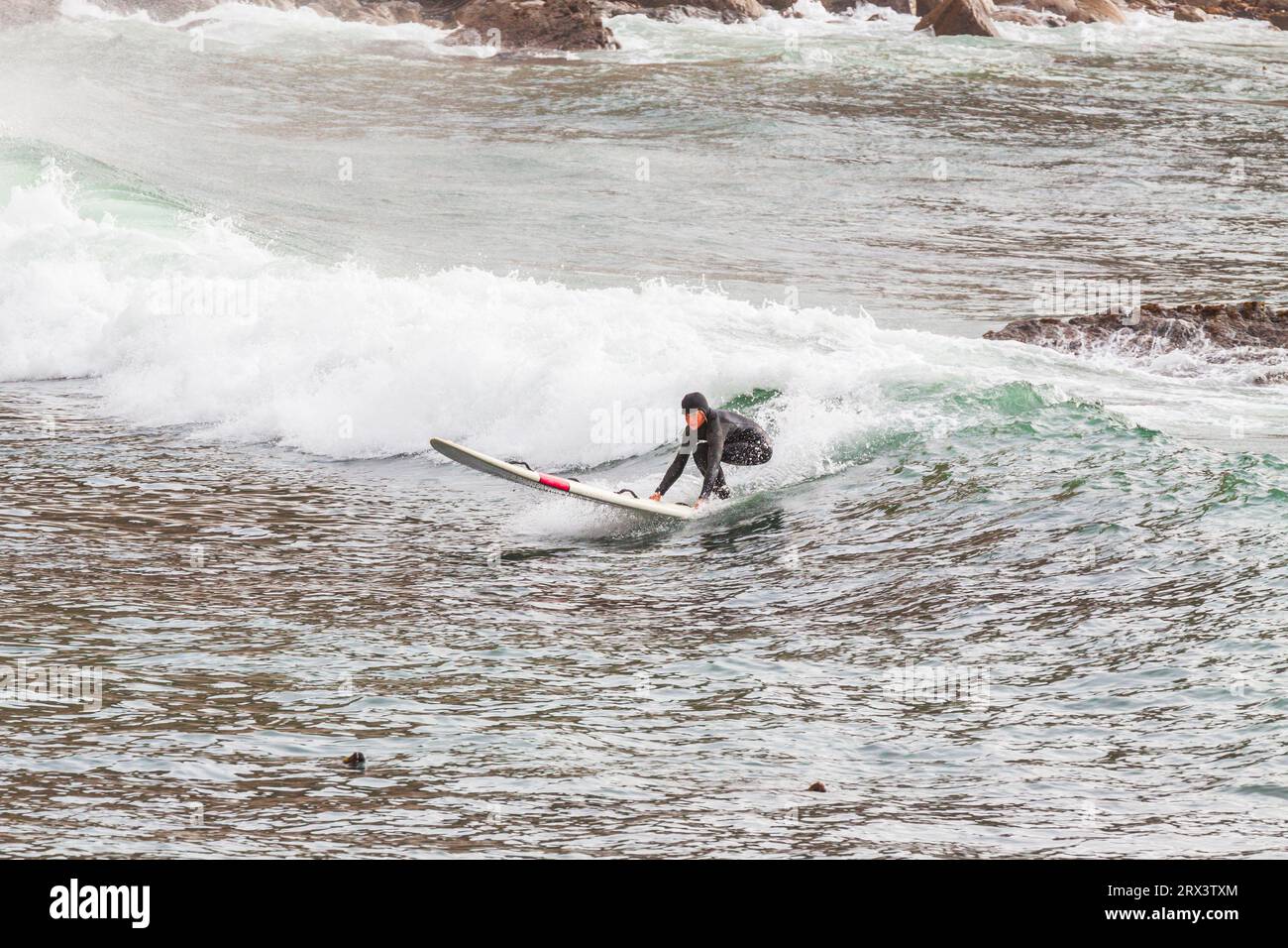 Surfeur attrapant une vague dans l'océan Pacifique à point Arena Pier Inlet sur la côte nord de la Californie. Banque D'Images